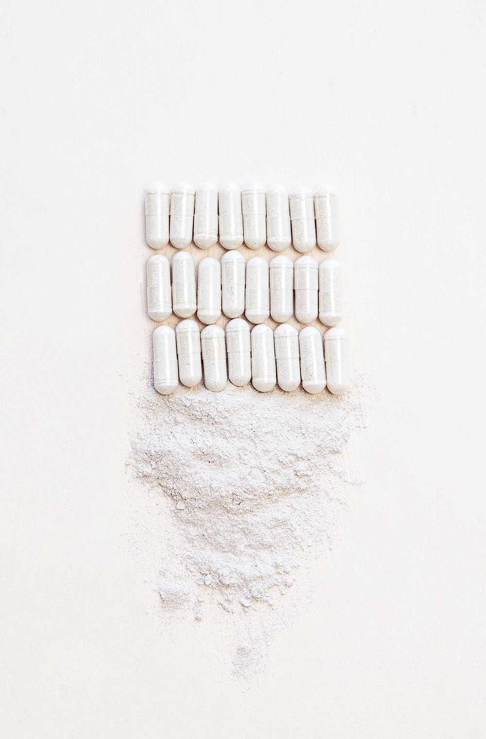 Supplement capsules with white powder.