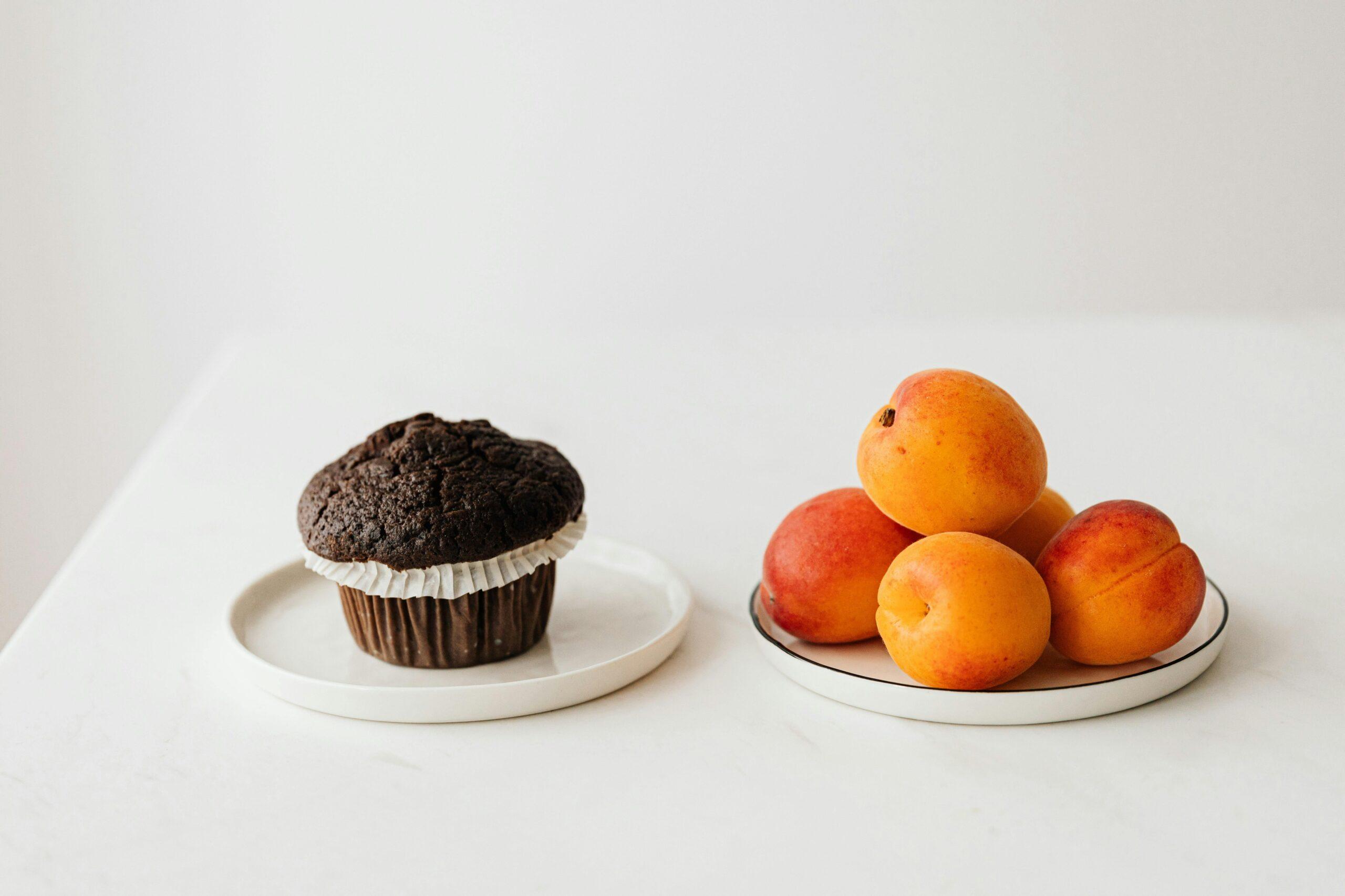 A chocolate muffin and a plate of peaches
