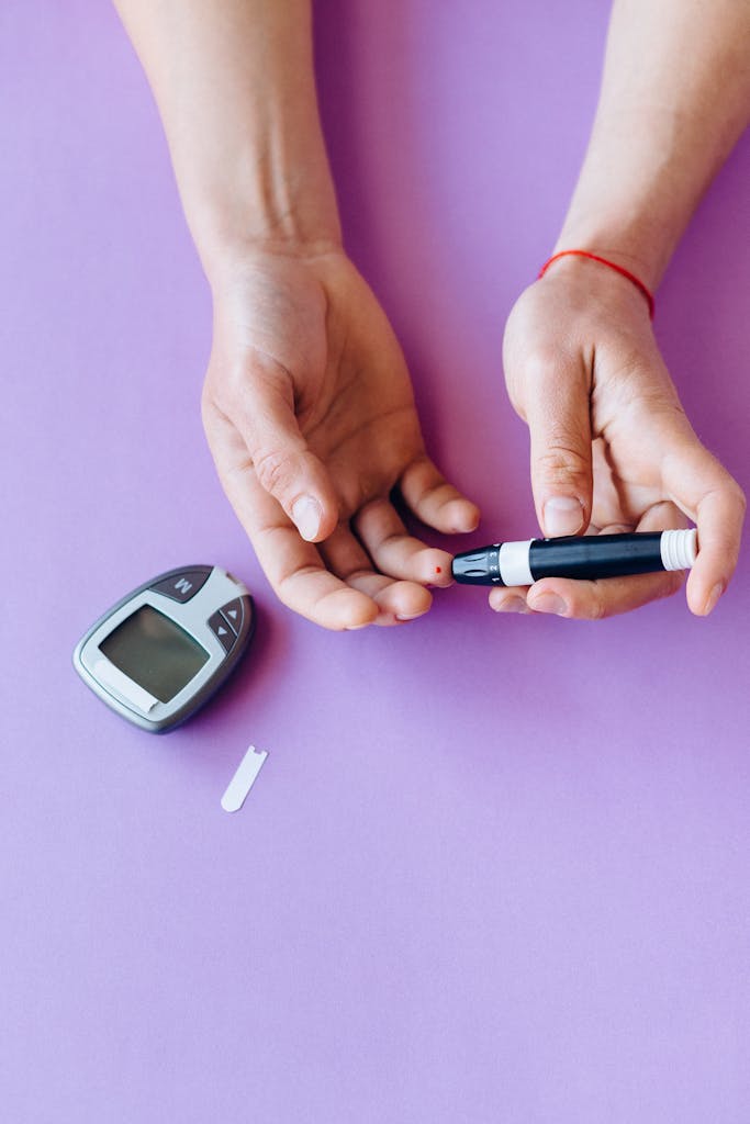 Person checking blood glucose level with glucometer on purple background.