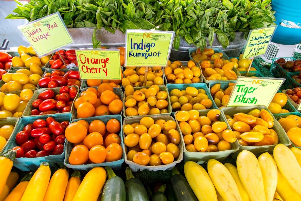 An array of colorful fresh fruits and vegetables on display at a lively farmers market stall.